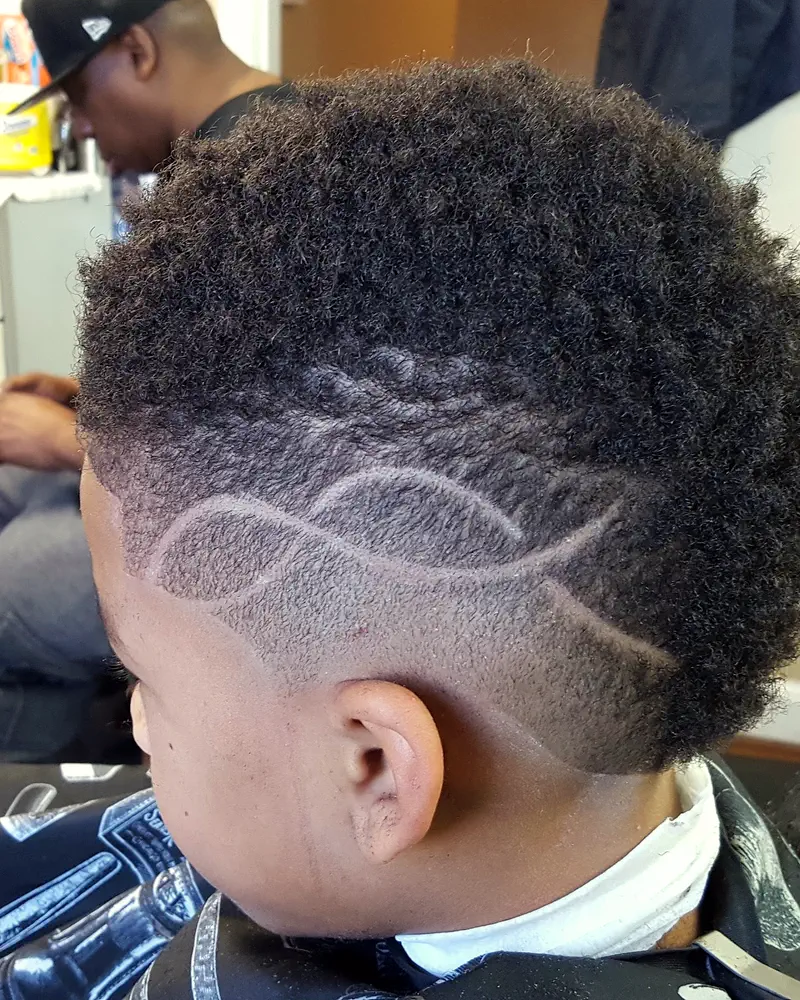 A boy's fade with a swirl design cut in, from behind
