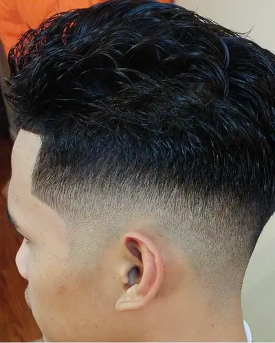 A skin fade with a sharp edge up, from the side
